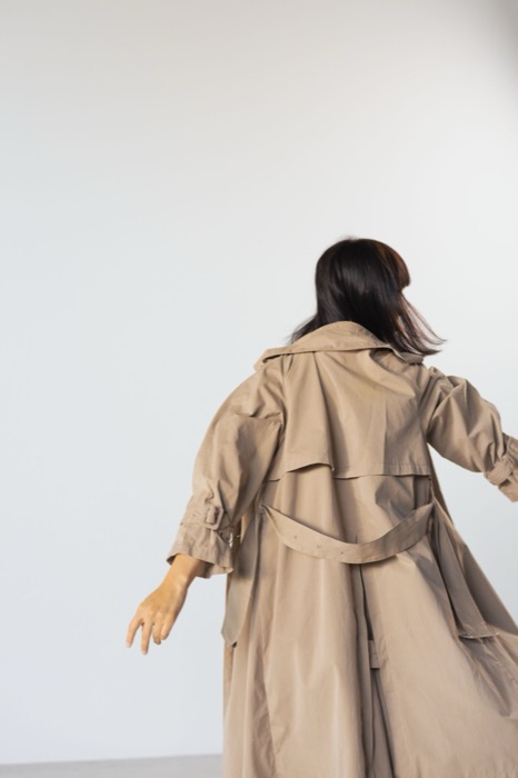 Sand trench coat in motion, seen from behind