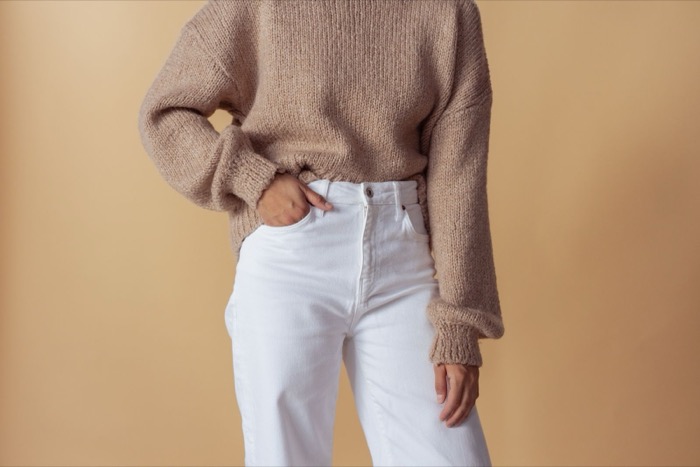 Oatmeal jumper tucked into white jeans